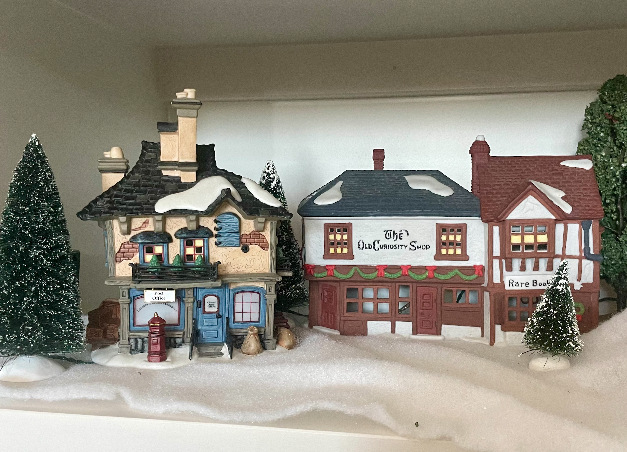two tiny ceramic houses decorated in the style of a British village in the 1840s.